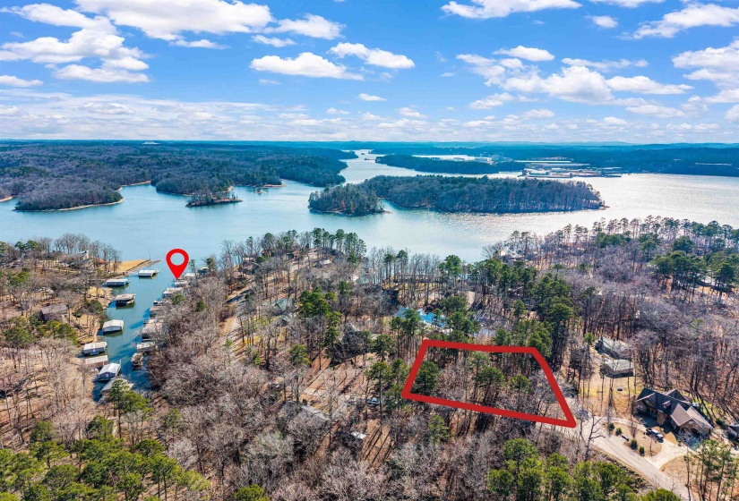 Aerial view of property and surrounding area featuring property parcel outlined and a nearby body of water