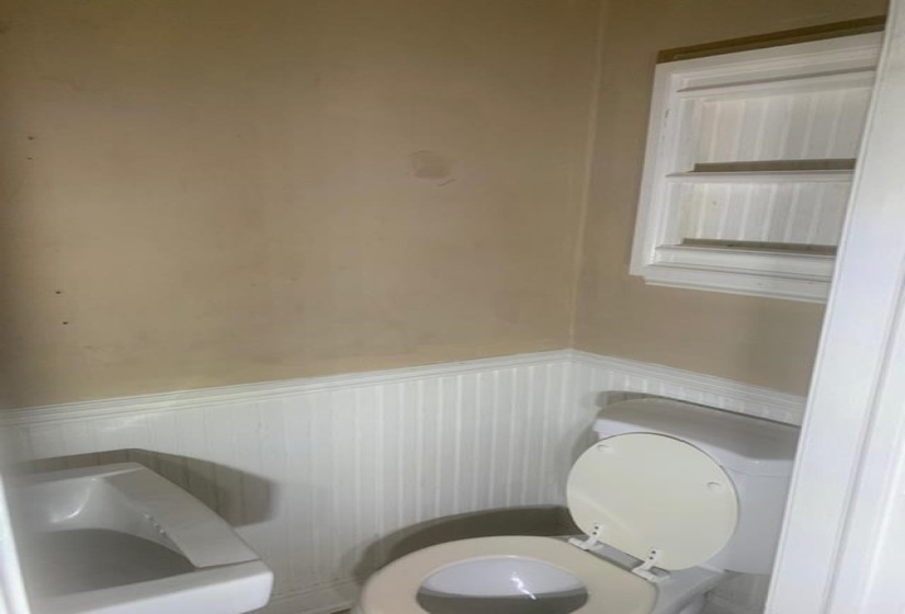 Bathroom with a wainscoted wall and toilet