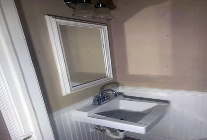 Bathroom view of a wainscoted wall and a sink