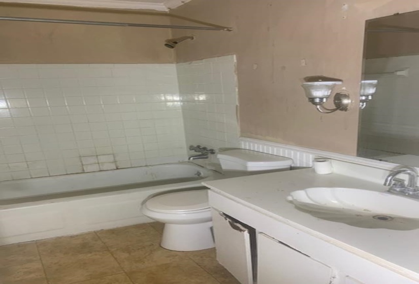 Bathroom featuring shower / bathtub combination, vanity, and light tile patterned flooring