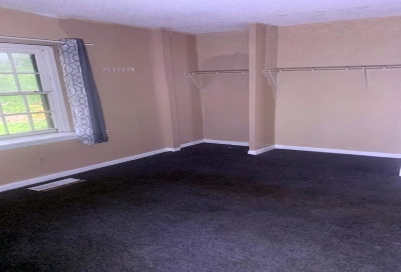 Walk in closet featuring dark colored carpet