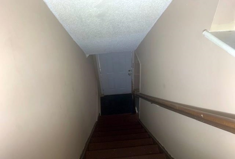 Stairs featuring a textured ceiling