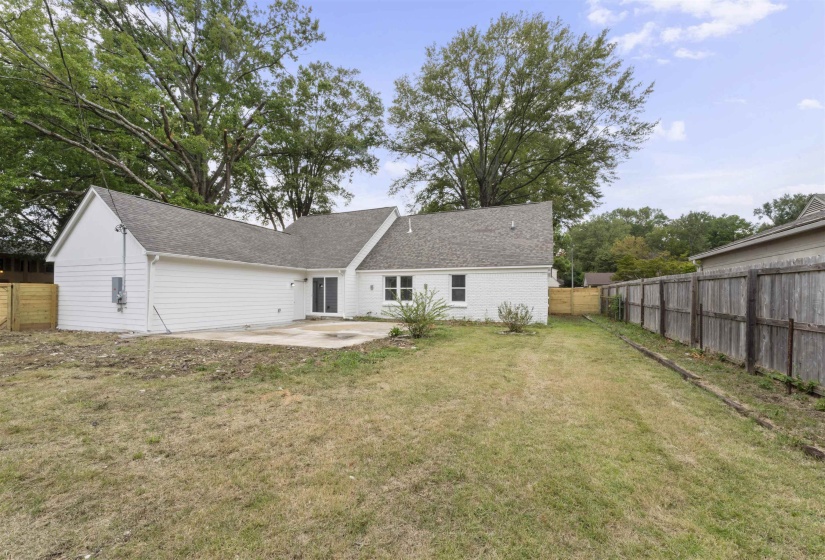 Back of property with a patio area, a fenced backyard, and roof with shingles