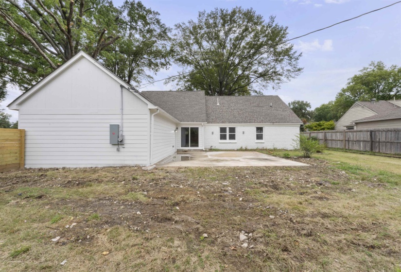 Rear view of house with a patio area, a fenced backyard, and a shingled roof