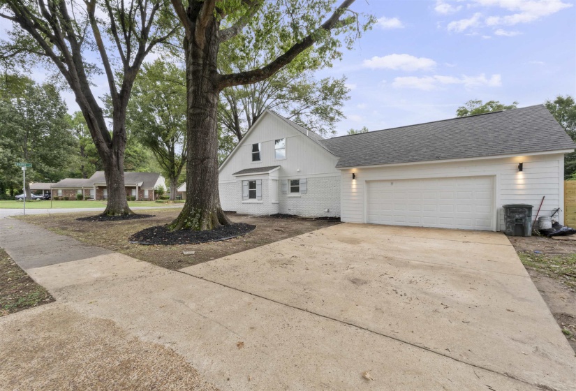 View of front of home featuring driveway, roof with shingles, brick siding, and an attached garage