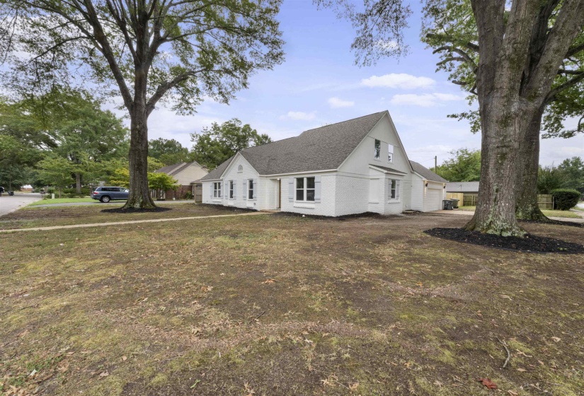 View of front of property featuring a front lawn, a garage, and a shingled roof