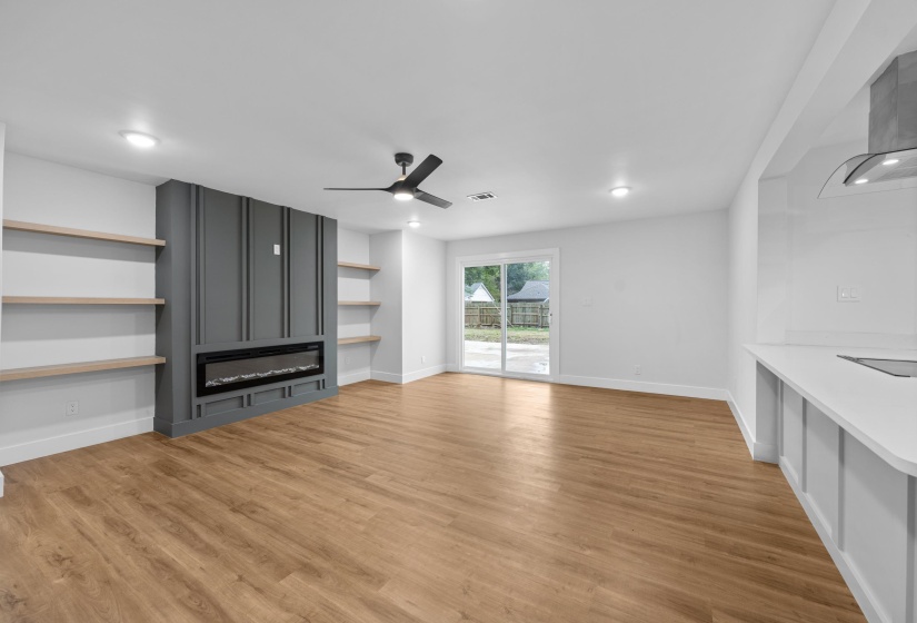 Unfurnished living room featuring light wood-style floors, a ceiling fan, recessed lighting, and a glass covered fireplace