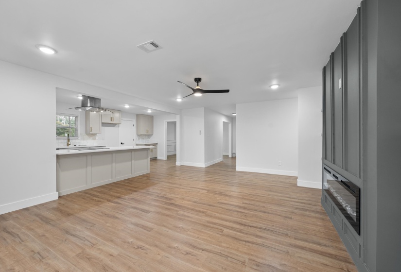 Unfurnished living room with light wood-style flooring, a ceiling fan, and recessed lighting