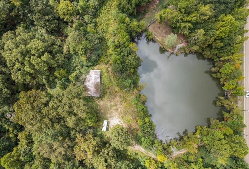 View of property location with a nearby body of water and a tree filled landscape