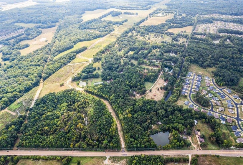 Aerial overview of property's location with a tree filled landscape