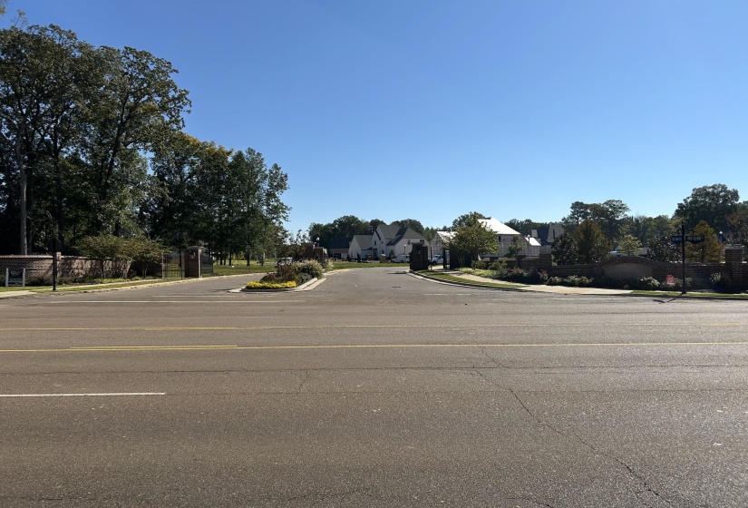 View of asphalt road featuring curbs and sidewalks