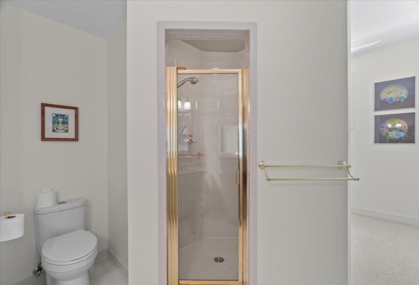 Bathroom featuring baseboards and a stall shower