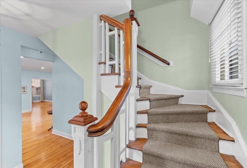 Stairway with healthy amount of natural light and wood finished floors