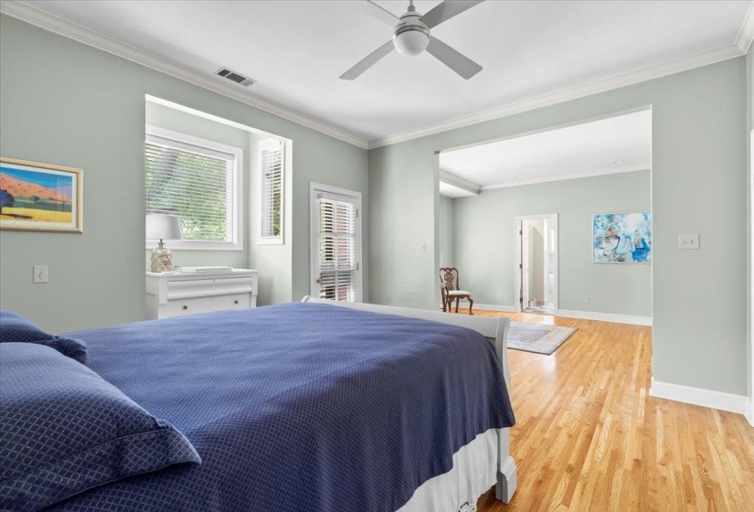 Bedroom featuring ornamental molding, light wood finished floors, and a ceiling fan