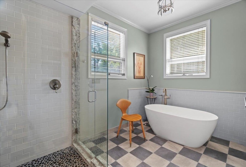 Full bath with a stall shower, crown molding, a freestanding bath, tile walls, and wainscoting
