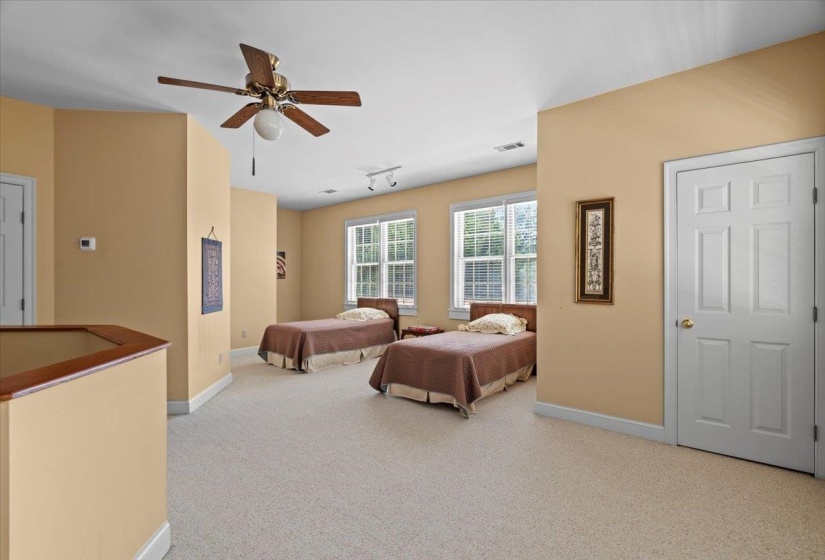 Carpeted bedroom featuring rail lighting and ceiling fan