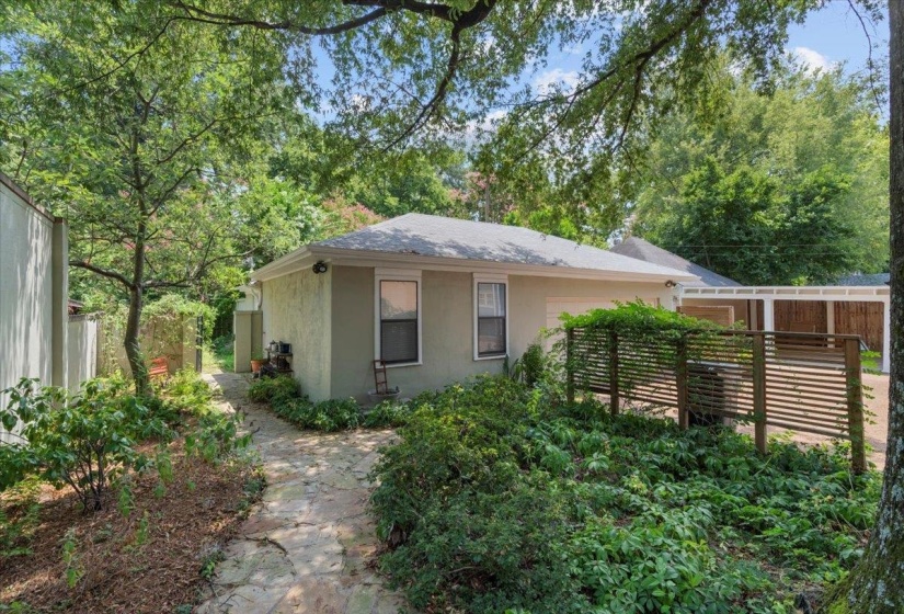 View of front of house featuring stucco siding and view of scattered trees