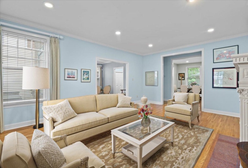Living room featuring light wood finished floors, crown molding, and recessed lighting