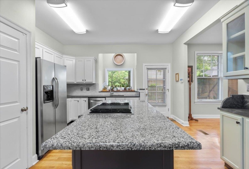 Kitchen with plenty of natural light, stainless steel appliances, light wood-style floors, and white cabinetry