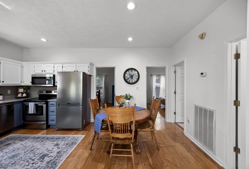 Dining space with light wood-type flooring, a textured ceiling, and recessed lighting