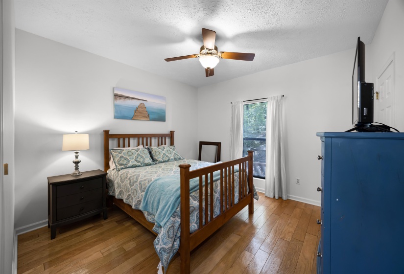 Bedroom with hardwood / wood-style floors, ceiling fan