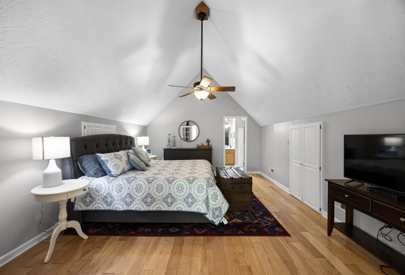 Bedroom with light wood-type flooring, vaulted ceiling, a ceiling fan