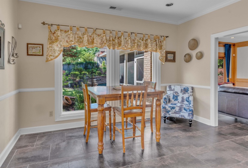 Spacious dining area featuring neutral wall tones, white trim, recessed lighting, and large format tile flooring