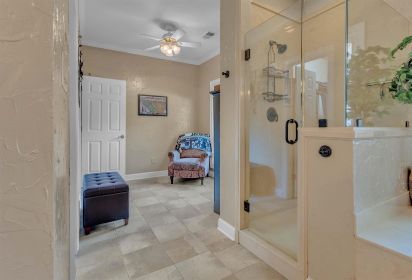 Tiled bathroom featuring a glass-enclosed shower with a black-framed door and wall-mounted shower system