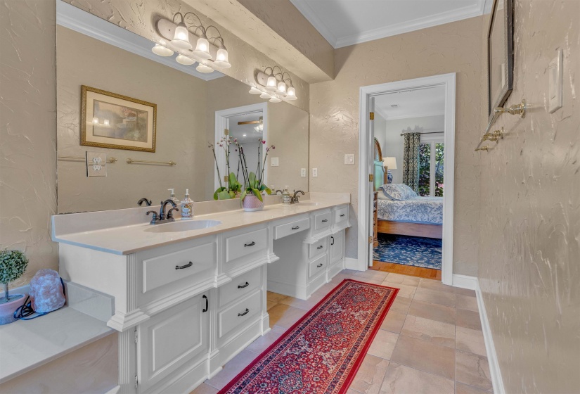 Dual vanity with white cabinetry and integrated sinks set beneath a large wall-mounted mirror