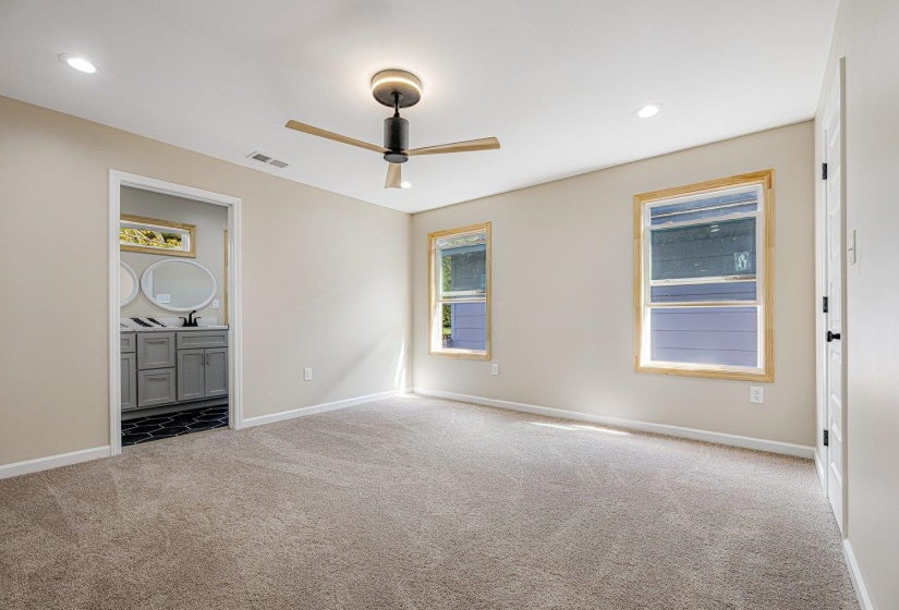 Unfurnished bedroom with light carpet, recessed lighting, a ceiling fan, and ensuite bathroom