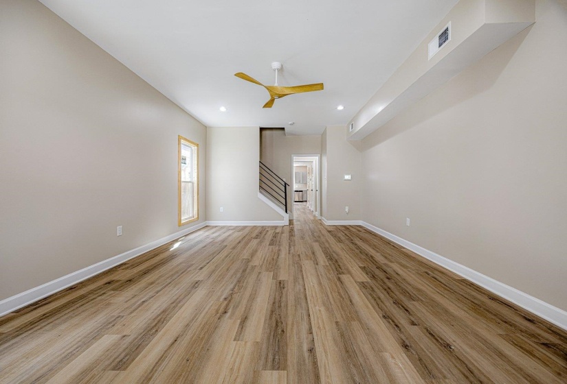Unfurnished room featuring light wood-style floors, a ceiling fan, stairs, and recessed lighting
