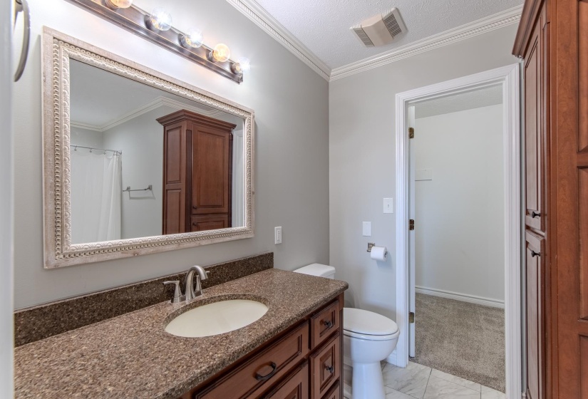 Full bath featuring ornamental molding, vanity, and a textured ceiling