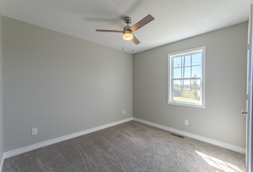 Carpeted spare room with ceiling fan and a textured ceiling
