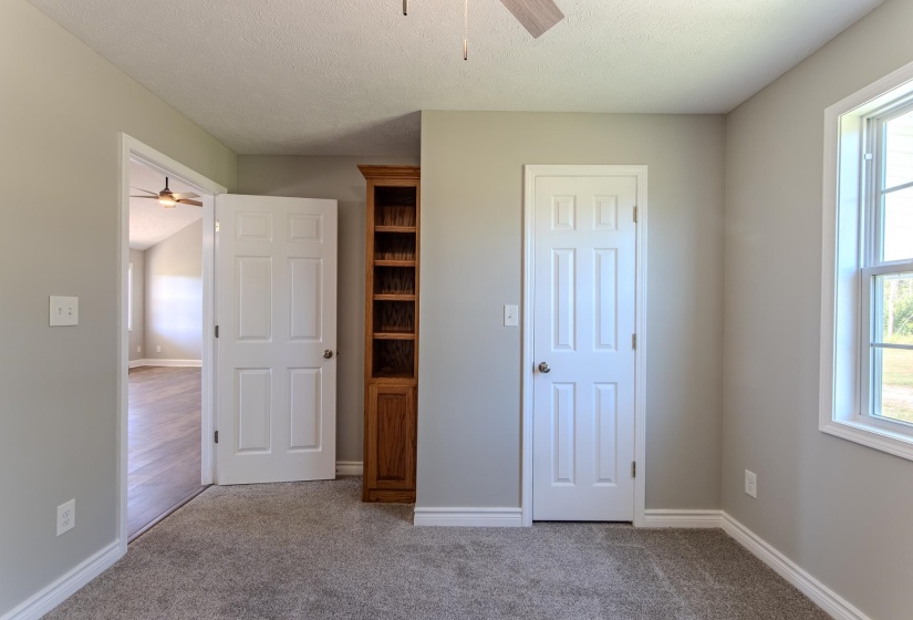 Unfurnished bedroom with multiple windows, carpet floors, a textured ceiling, and a ceiling fan