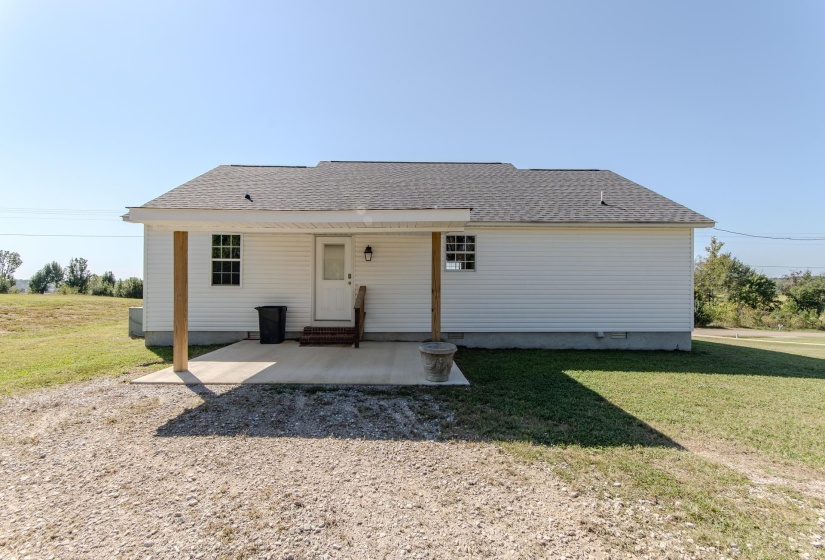 Rear view of house featuring a yard, roof with shingles, a patio area, and entry steps