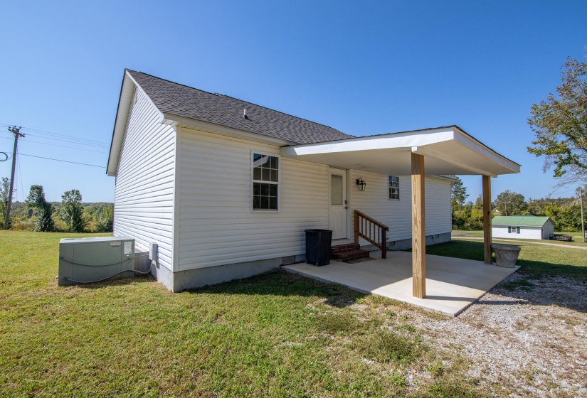 Back of property with a yard, roof with shingles, entry steps, and a patio