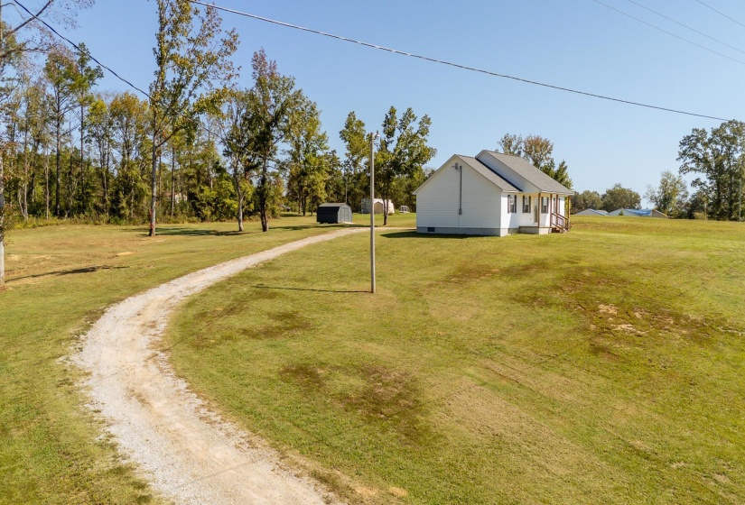 View of grassy yard featuring driveway