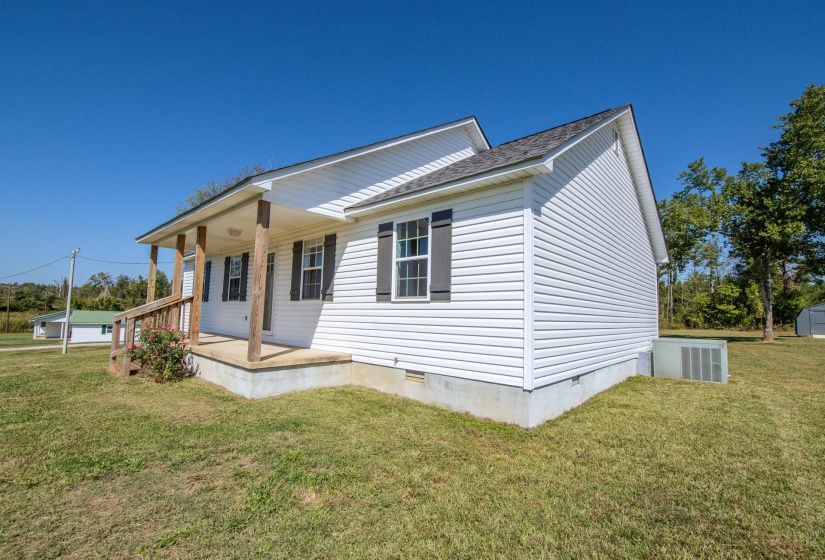 View of front of property with crawl space, covered porch, a front yard, and an outdoor structure