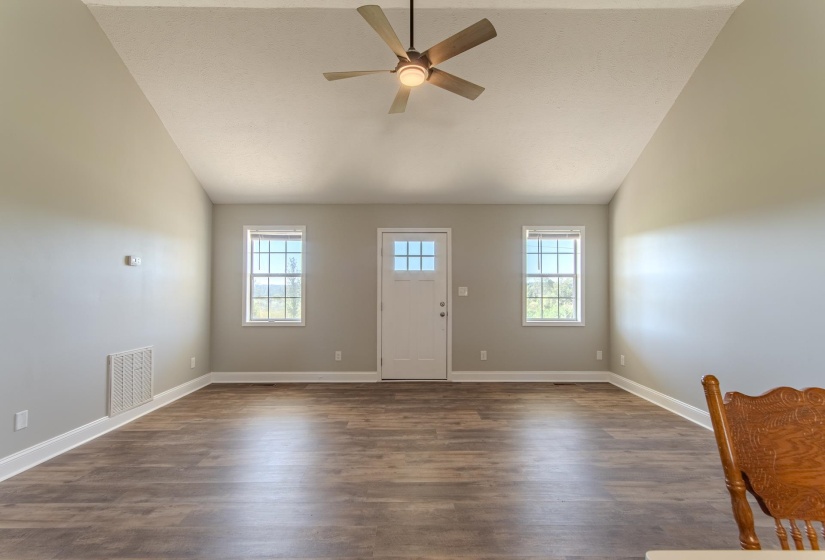 Foyer with lofted ceiling, healthy amount of natural light, dark wood-style flooring, and ceiling fan