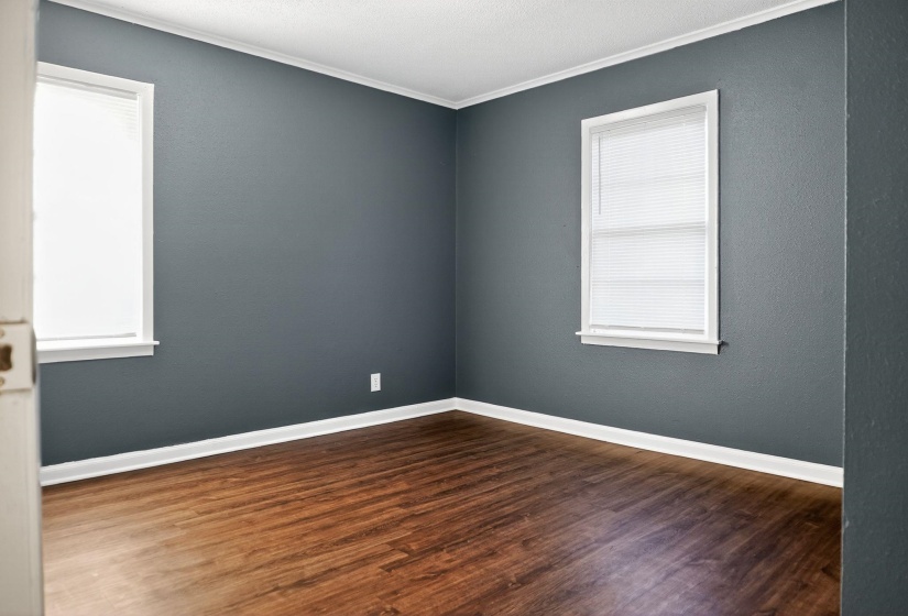 Spare room featuring dark wood-style flooring and crown molding