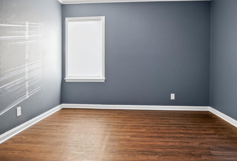 Unfurnished room with dark wood finished floors and a textured wall