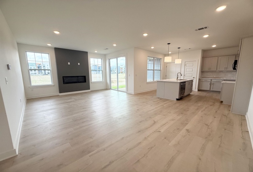 Unfurnished living room with recessed lighting, light wood-style flooring, and a large fireplace