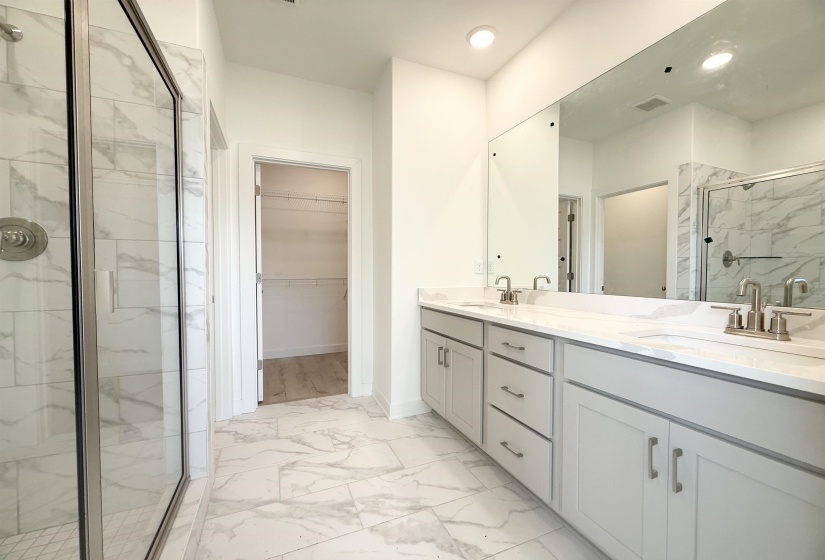 Full bathroom with a marble finish shower, marble finish floors, a walk in closet, double vanity, and recessed lighting