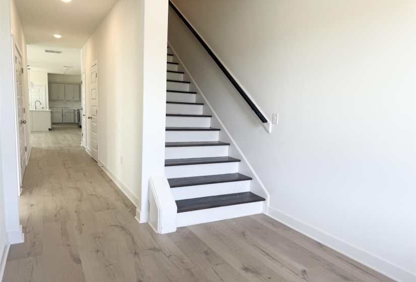 Staircase featuring wood finished floors and recessed lighting