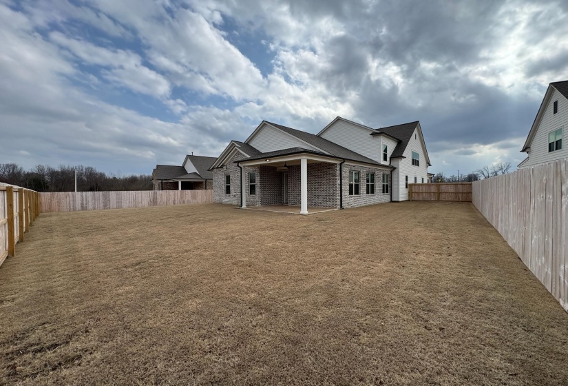 Back of house featuring a patio area, a fenced backyard, and brick siding