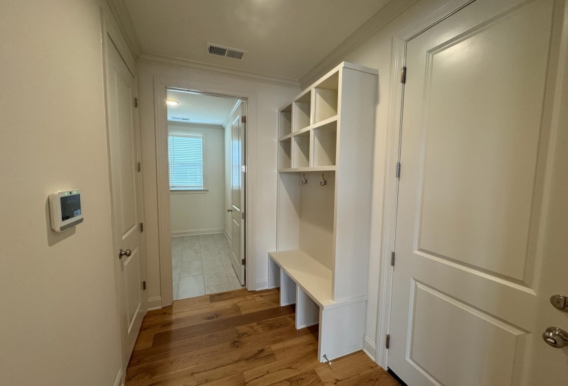 Mudroom with ornamental molding and light wood-style floors