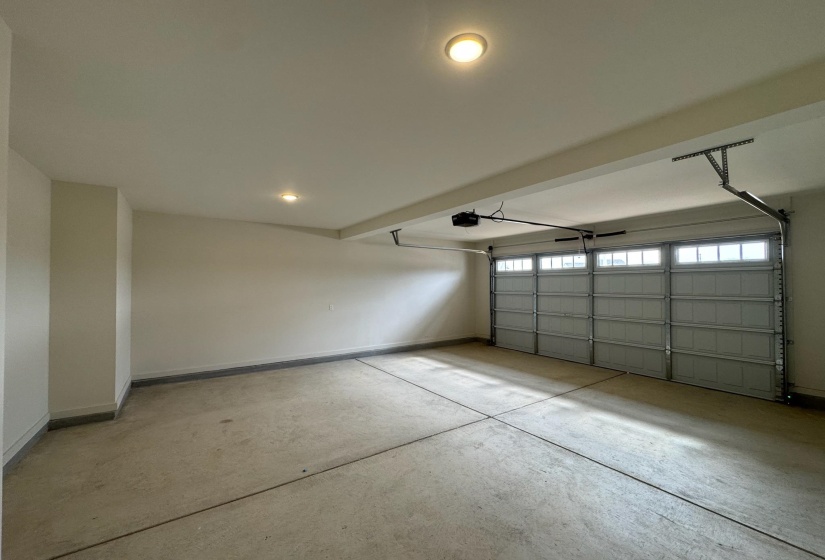 Garage with baseboards and a garage door opener