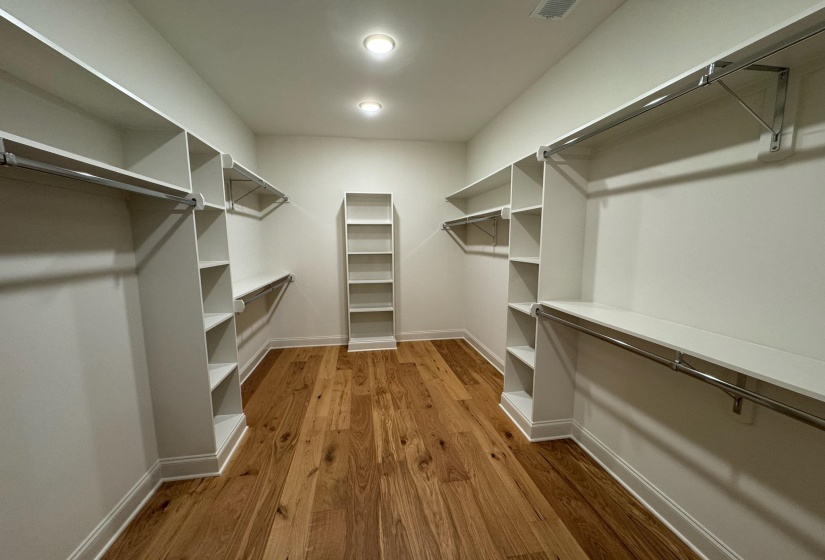 Walk in closet with dark wood-style floors