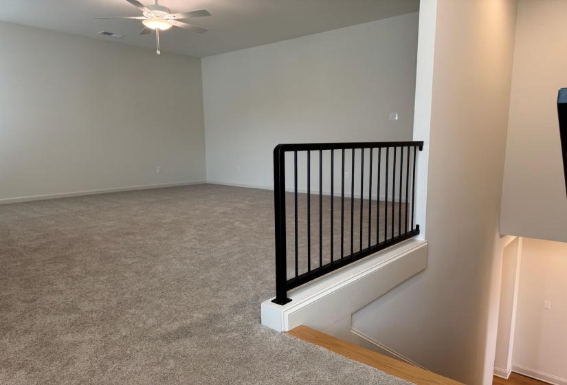 Spare room with a ceiling fan and light colored carpet