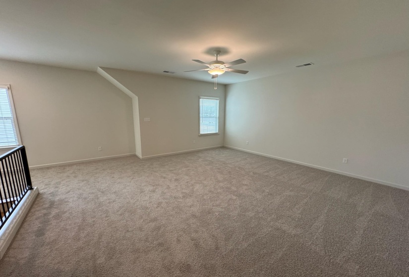 Empty room with ceiling fan and carpet flooring
